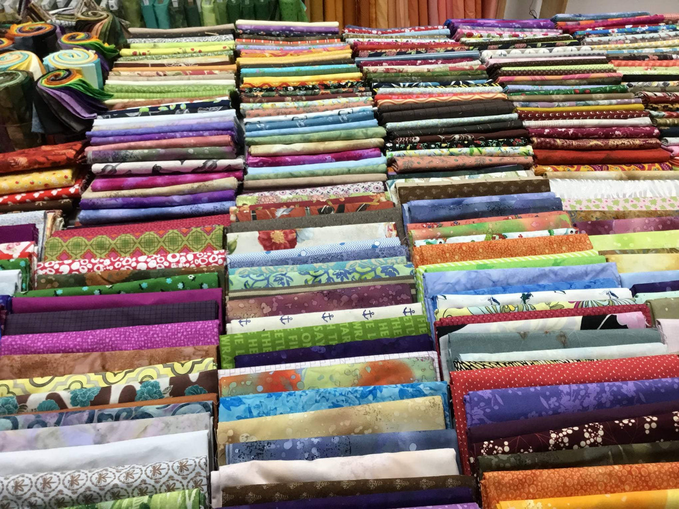 Large collection of quilts with different colors at The Quilt Place